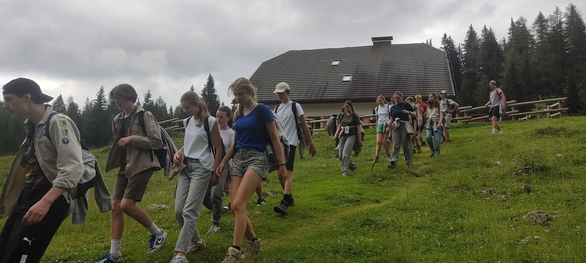 Givers met rugzak en wandelstok op trektocht langs een berghut